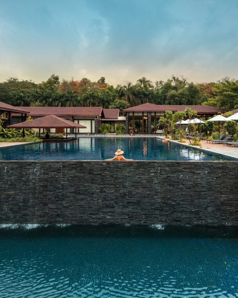 Infinity pool with scenic hill view at Oleander Farms